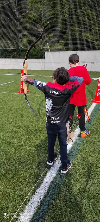 arqueros jovenes tirando con arcos desnudos