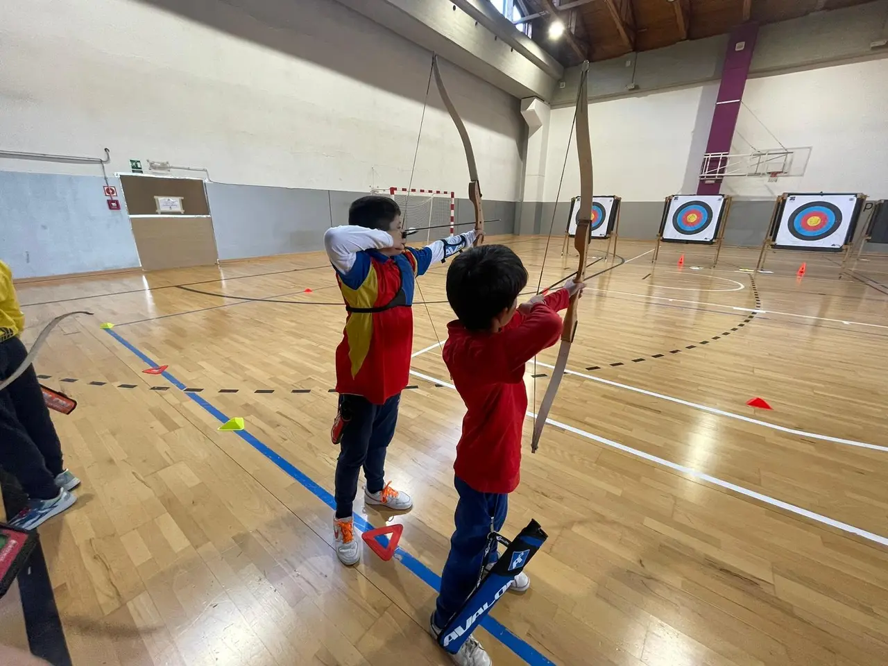 dos arqueros jovenes tirando con arco desnudo