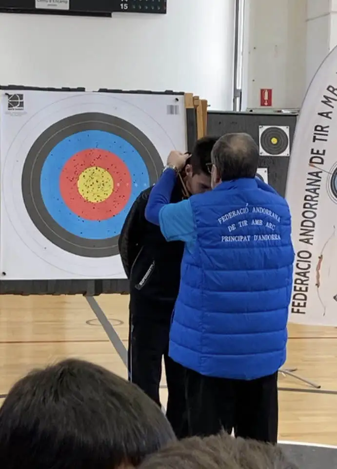 juez otorgando medalla a un arquero