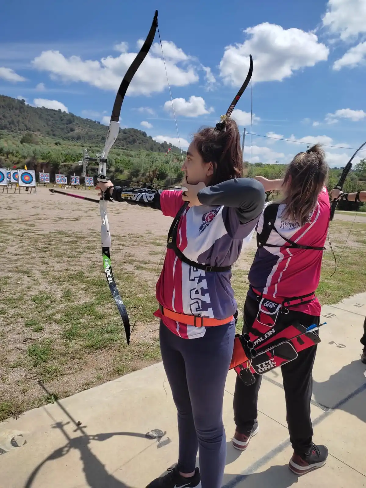 dos arqueras jovenes tirando con arco recurvo