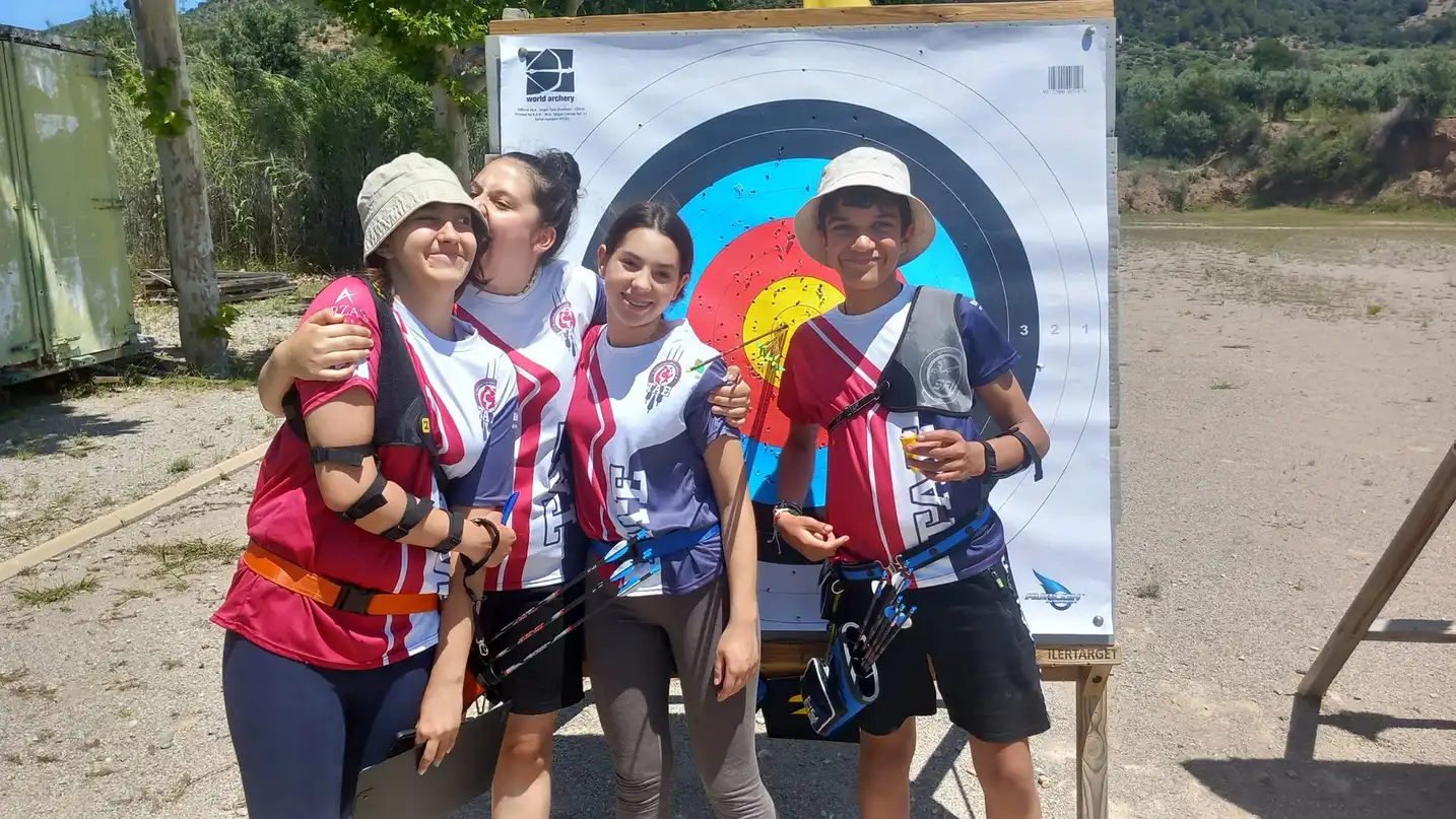 arqueros jovenes con la diana de fondo